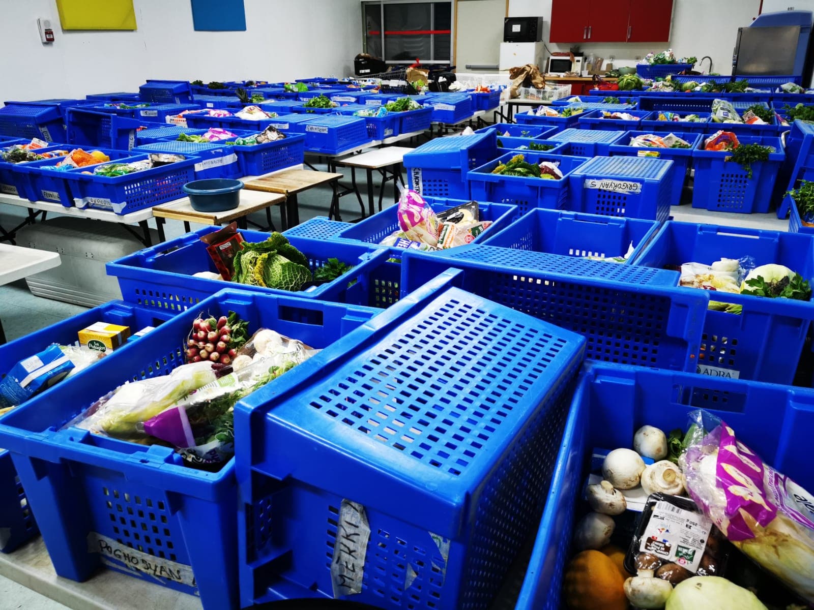 Baguettes et pains empilés, caisses bleues en arrière-plan